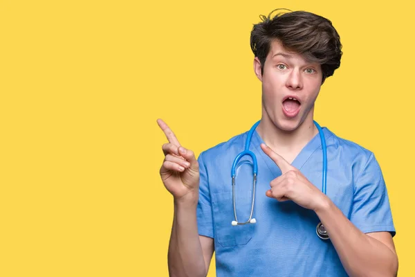 Junger Arzt Uniform Vor Isoliertem Hintergrund Lächelnd Und Mit Zwei — Stockfoto