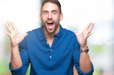 Yakışıklı delikanlı deli kutluyor ve silah ile başarı için heyecanlı çığlık kaldırdı ve açık gözleri hayret izole arka plan üzerinde. Kazanan kavramı