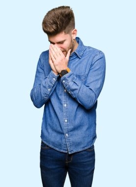 Üzgün ifade yüz eller ile ağlayarak süre kapsayan ile rahat kot gömlek giymiş genç yakışıklı sarışın adam. Depresyon kavramı.