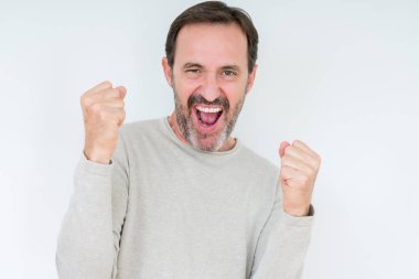 Gülümseyen ve başarı için çığlık zarif üst düzey adam izole arka plan çok mutlu ve heyecanlı kaldırdı, silah ile kazanan jest yapıyor. Kutlama kavramı.