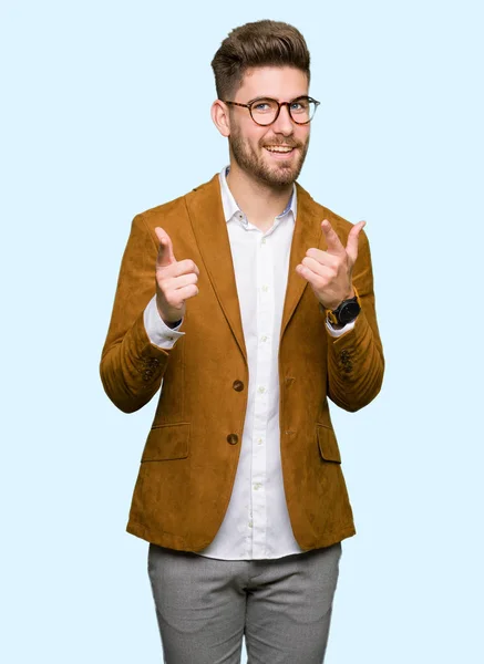 若いハンサムなビジネス男が眼鏡をかけて幸せで面白い顔でカメラに指を指しています 良いエネルギーとヴァイブス — ストック写真