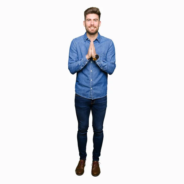 Νέος Όμορφος Ξανθός Άντρας Φορώντας Casual Denim Πουκάμισο Προσεύχεται Χέρια — Φωτογραφία Αρχείου