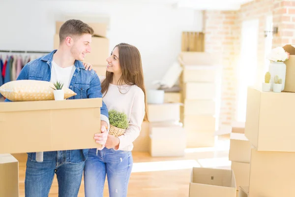 Hermosa pareja joven sonriendo en amor sosteniendo cajas de cartón , —  Fotos de Stock
