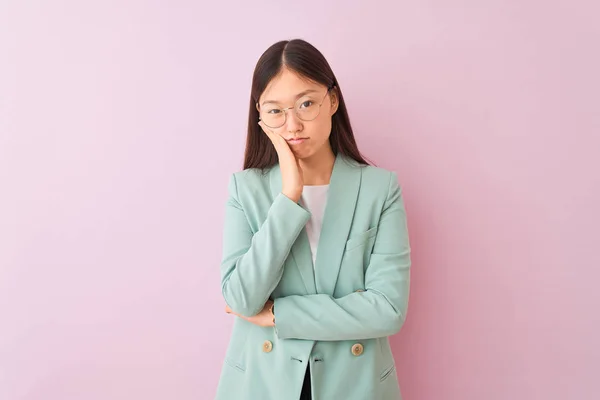 Young chinese businesswoman wearing jacket and glasses over isolated pink background thinking looking tired and bored with depression problems with crossed arms.