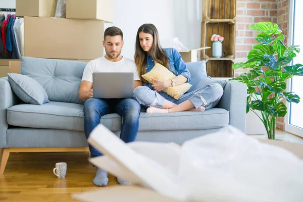 Joven Hermosa Pareja Relajante Sentado Sofá Nueva Casa Utilizando Ordenador — Foto de Stock