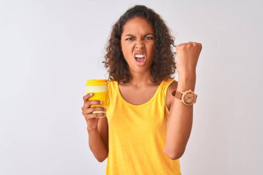 Genç Brezilyalı kadın içme izole beyaz arka plan üzerinde duran kahve götürmek kızgın ve sinirli öfke ile bağırarak, deli ve yükseltilmiş el ile bağırıyor, öfke kavramı
