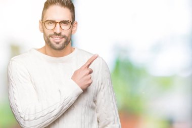 Genç yakışıklı adam gözlük izole üzerinde işaretçi el parmak reklam, ciddi ve sakin yüz gösterilen yan için arka plan