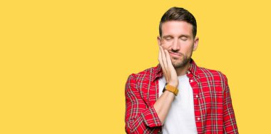 Diş ağrısı veya dişlerde dişlerle ilgili hastalık nedeniyle ağız acı ifadesi ile el ile dokunmak rahat gömlek giymiş yakışıklı adam. Diş hekimi kavramı.