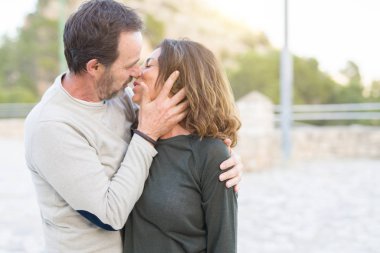 Romantik çift gülümseyerek ve güneşli bir aşk öpüşme sarılma 