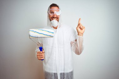 Ressam adam izole arka plan üzerinde rulo tutan profesyonel işçi ekipmanları giyen çok mutlu yan el ve parmak ile işaret