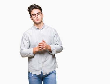 Arka plan eller üzerinde gözlük takan genç yakışıklı adam birlikte izole ve rahat ve neşeli gülümseyen parmak çarpı işareti. Başarı ve iyimser