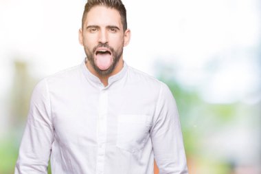 Genç iş adamı dilini izole arka plan üzerinde out komik ifade ile mutlu. Duygu kavramı.