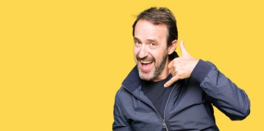 Orta yaş yakışıklı adam yapıyor gülümseyen bir ceket telefon hareketi ile el ve parmak telefonda konuşuyor gibi. Kavramları iletişim.