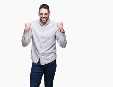 Yakışıklı delikanlı üzerinde güneş gözlüğü takıyor arka plan çok mutlu ve heyecanlı kaldırdı, silah ile kazanan jest yapıyor gülümseyen ve başarı için çığlık izole. Kutlama kavramı.