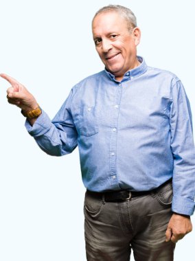 Yüzünde, kocaman bir gülümseme ile şık gömlek giymiş yakışıklı üst düzey businesss adam kameraya bakarak yan el ve parmak ile işaret.