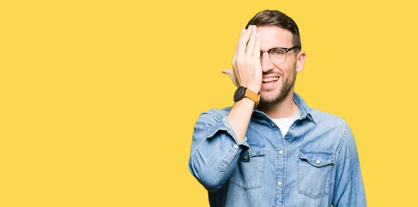 Hombre Guapo Con Gafas Cubriendo Ojo Con Mano Con Sonrisa —  Fotos de Stock