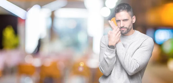 Joven Hombre Guapo Usando Sudadera Sobre Fondo Aislado Sosteniendo Arma —  Fotos de Stock