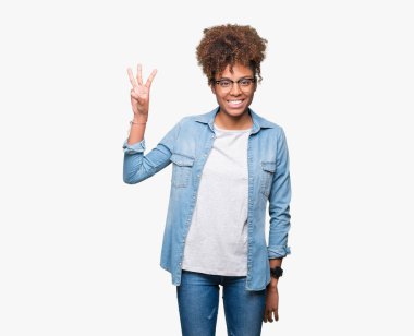 Güzel genç Afro-Amerikan kadın gözlük gösterilen ve parmakları ile işaret izole arka plan üzerinde ise kendinden emin ve mutlu gülümseyerek üçüncüsü.