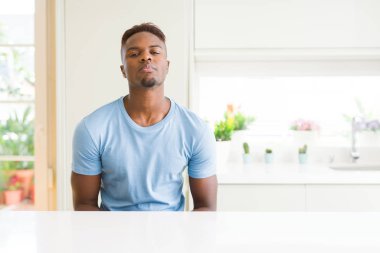 Yakışıklı afro-amerikan adam evde rahat t-shirt giyen yüzünde ciddi ifade ile rahat. Kameraya basit ve doğal bir bakış.