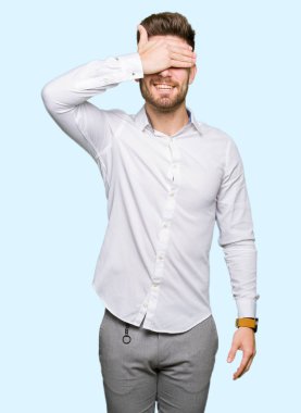 Gülümsüyor ve gözleri için sürpriz kapsayan yüz el ile gülüyor genç yakışıklı iş adamı. Kör kavramı.