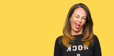 Rock'n roll kazak seksi bir ifadeyle, neşeli ve mutlu yüzünü kameraya bakarak göz kırpıyor giyen güzel orta yaş kadın.