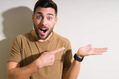 Izole arka plan üzerinde genç yakışıklı adam çok mutlu el ve parmak ile işaret