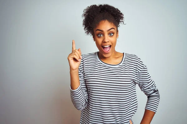 줄무늬 티셔츠를 서있는 아프리카 미국인 여성이 성공적인 아이디어로 손가락을 가리킵니다 — 스톡 사진