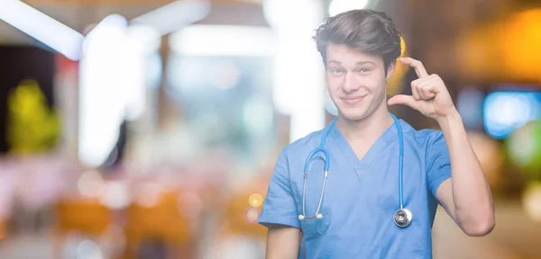 Mladý Doktor Lékařských Uniformě Usmívá Izolovaná Pozadí Jistý Ukázal Rukou — Stock fotografie