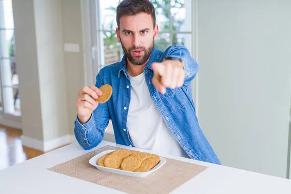 Beau Homme Mangeant Biscuit Sain Grains Entiers Pointant Doigt Vers — Photo