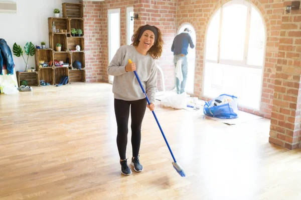 Femme d'âge moyen avec les cheveux bouclés de travail nettoyage de la maison usin — Photo