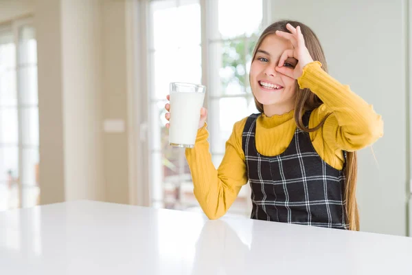 美しい若い女の子は 指を通して見て目に手でOkサインをやって笑顔で幸せな顔で新鮮なミルクのグラスを乾燥 — ストック写真