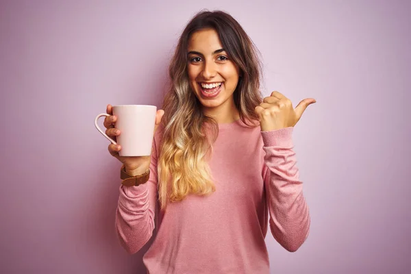Młoda Piękna Kobieta Trzyma Filiżankę Kawy Różowym Białym Tle Wskazując — Zdjęcie stockowe