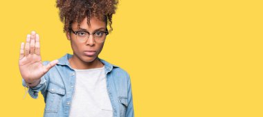 Güzel genç Afro-Amerikan kadın gözlük stop yapıyor izole arka plan üzerinde elin avuç ile şarkı. Negatif ve ciddi bir jest yüz ifadesiyle uyarı.