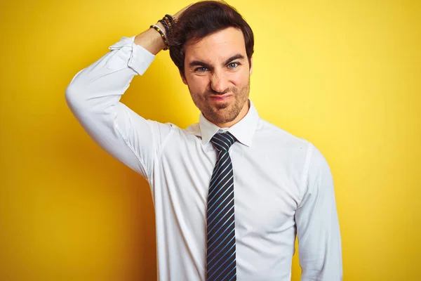 エレガントなシャツを着て 孤立した黄色の背景の上にネクタイを着て若いハンサムなビジネスマンは 質問について混乱し 不思議に思います 頭の上に手を置いて考え 疑いを持って不確か ペンシブコンセプト — ストック写真