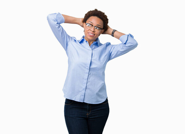 Молодая красивая африканская деловая женщина на изолированном фоне расслабляется и растягивается с руками и руками за головой и шеей, улыбаясь счастливой
