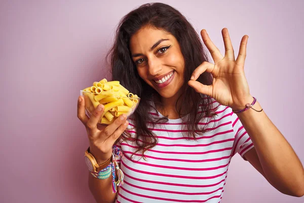 Young Beautiful Woman Holding Bowl Dry Macaroni Pasta Isolated Pink — Stock Photo, Image