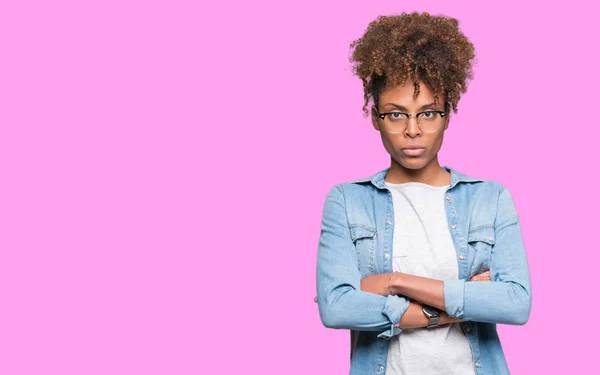 美しい若いアフリカ系アメリカ人女性の孤立した背景の懐疑論者と組んだ腕で顔の神経 不賛成式メガネを着用します 否定的な人 — ストック写真