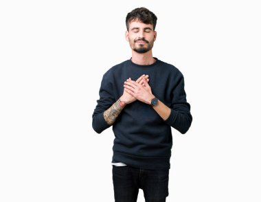 Yakışıklı delikanlı ile gülümseyen izole arka plan üzerinde kapalı gözler ve yüzünde minnettar jest ile göğüs üzerinde eller. Sağlık kavramı.