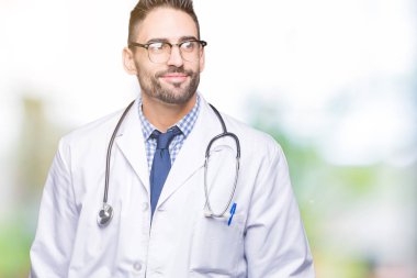Yakışıklı genç adam görünümlü yan ve dik dik bakma uzağa düşünce gülümseyen izole arka plan üzerinde doktor..