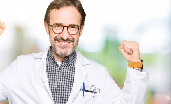 中年医生男子穿着医疗外套显示手臂肌肉微笑自豪 健身理念 — 图库照片