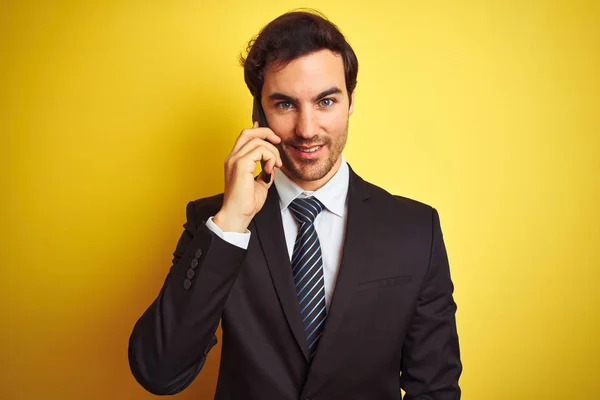 Молодой Красивый Бизнесмен Разговаривает Смартфону Изолированном Желтом Фоне Счастливым Лицом — стоковое фото