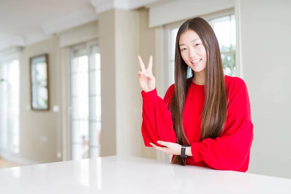 Beyaz Masada Kırmızı Kazak Giyen Güzel Asyalı Kadın Mutlu Yüz — Stok fotoğraf