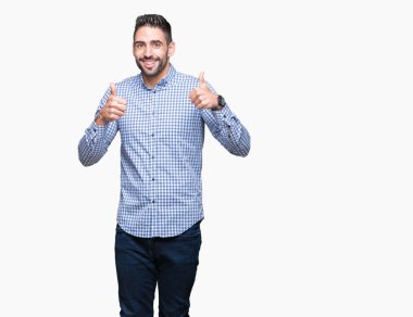 Yakışıklı delikanlı izole arka plan başarı işareti el ile pozitif jest yapıyor üzerinde başparmak gülümseyen ve mutlu. Neşeli bir ifadeyle, kazanan jest kameraya bakıyor.