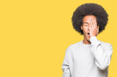 Afrikalı-Amerikalı genç afro saçlı sportif kazak yarım yüz, göz ve ağız el ile kapsayan yorgun esneme giyiyor. Acı yüzü acıyor.