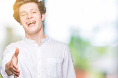 Genç yakışıklı iş adamı tebrik ve konuksever dost sunan karşılıklı gülümseyen izole arka plan üzerinde. Başarılı iş.