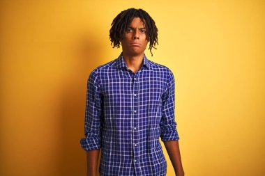 Yalnız sarı arka plan depresif ve sıkıntı için endişe, kızgın ve korkmuş ağlama üzerinde duran rahat gömlek giyen dreadlocks ile Afro adam. Hüzünlü ifade.