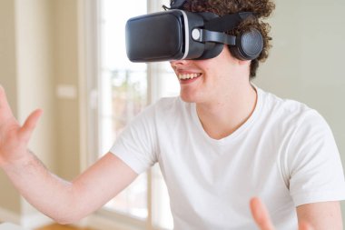 Genç adam eğleniyor evde sanal gerçeklik gözlüklü