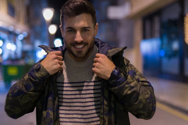 Junger gutaussehender Mann, der posiert und lächelt. Straßenstil bei Nacht — Stockfoto