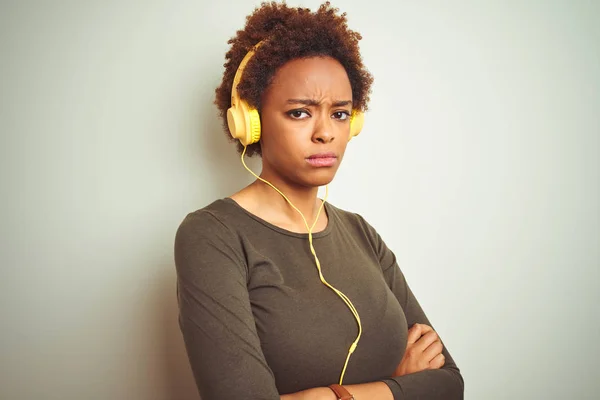 Mujer Afroamericana Con Auriculares Escuchando Música Sobre Fondo Aislado Escéptico —  Fotos de Stock