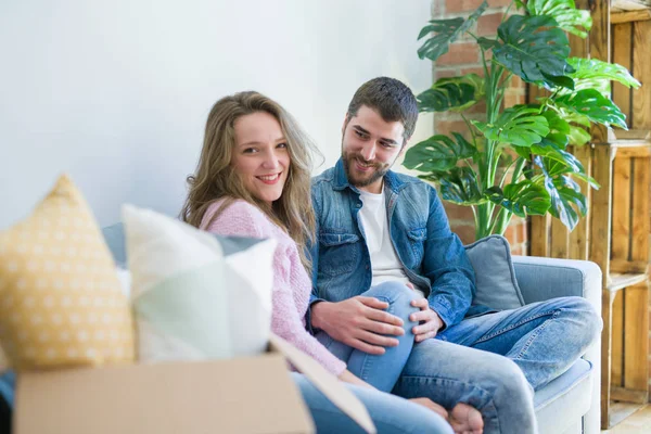 Junges verliebtes Paar umarmt sich auf dem Sofa sitzend sehr glücklich — Stockfoto